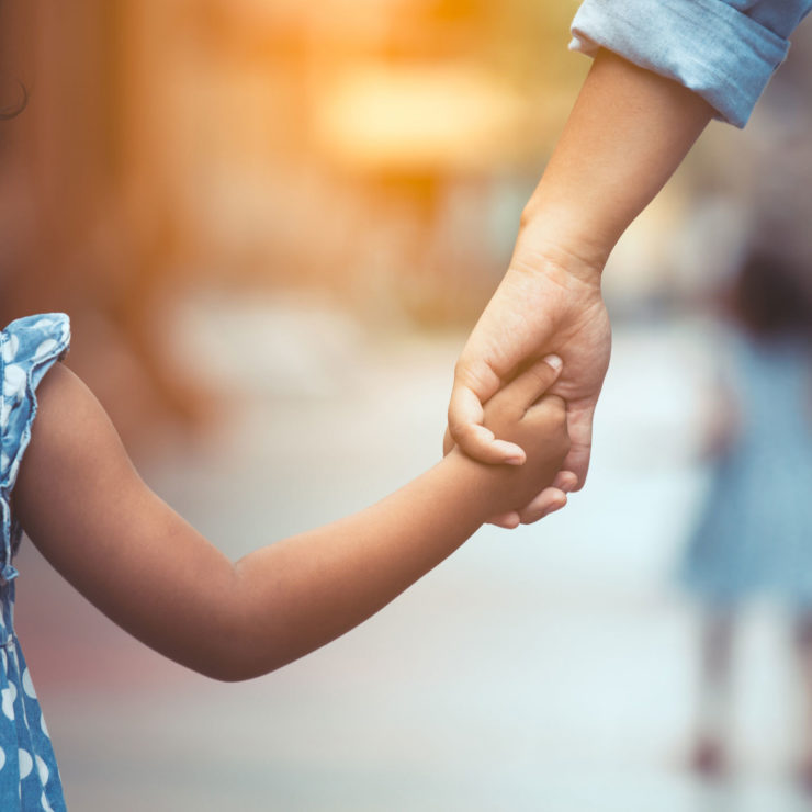 Person Holding A Childs Hand And Walking