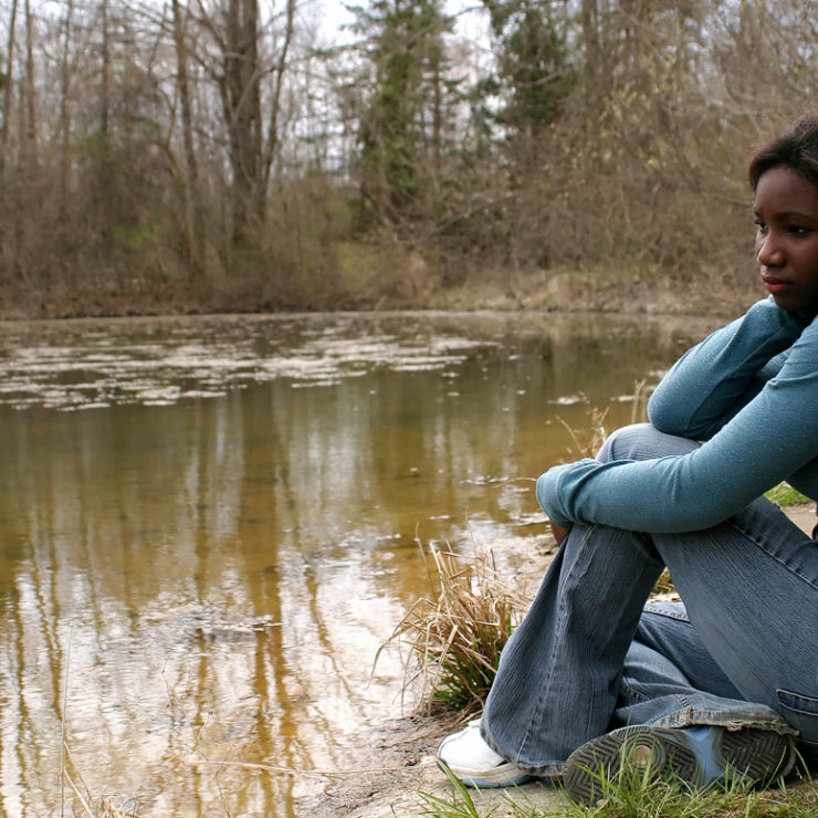 Young woman reflecting near pond by JamieWilson via iStockphoto