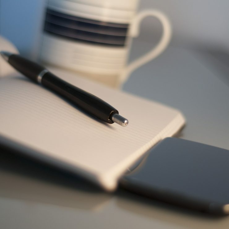 A pen lying on top of a notebook to demonstrate good leadership