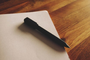 Pen lying on an open, blank notebook page