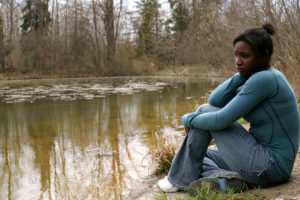 Young woman reflecting near pond by JamieWilson via iStockphoto