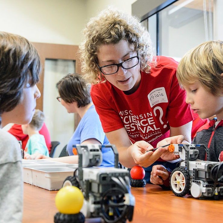 Photo of woman interacting with children at science festival by Bryce Richter from University Communications