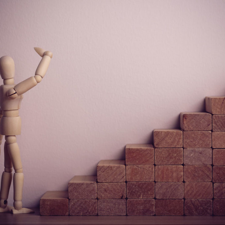 Wooden Figure Contemplating Climbing Stairs