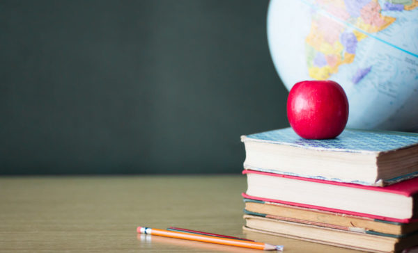 Classroom desk with apple by Andrea Carolina Sanchez Gonzalez via iStock