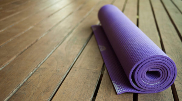 Photo of yoga mat on wooden floor by Cindybug via iStock