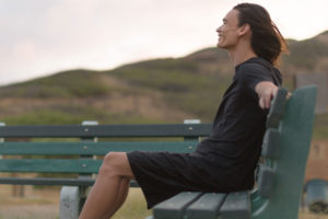 Young Man On A Park Bench Smiling